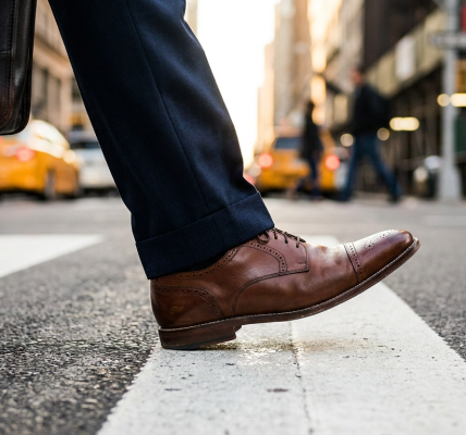 Close-up shot of a man's brown dress shoes crossing a pedestrian lane.