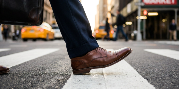 Close-up shot of a man's brown dress shoes crossing a pedestrian lane.